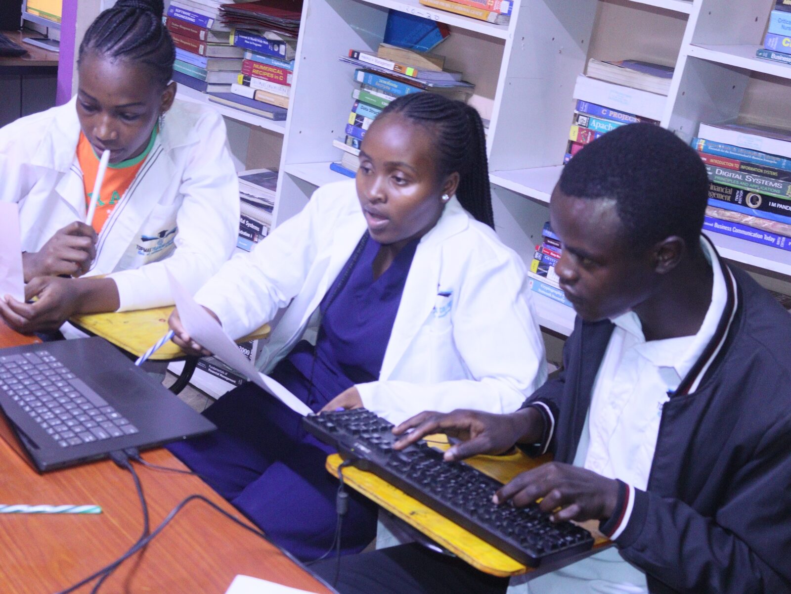 Students using computers and printed learning materials